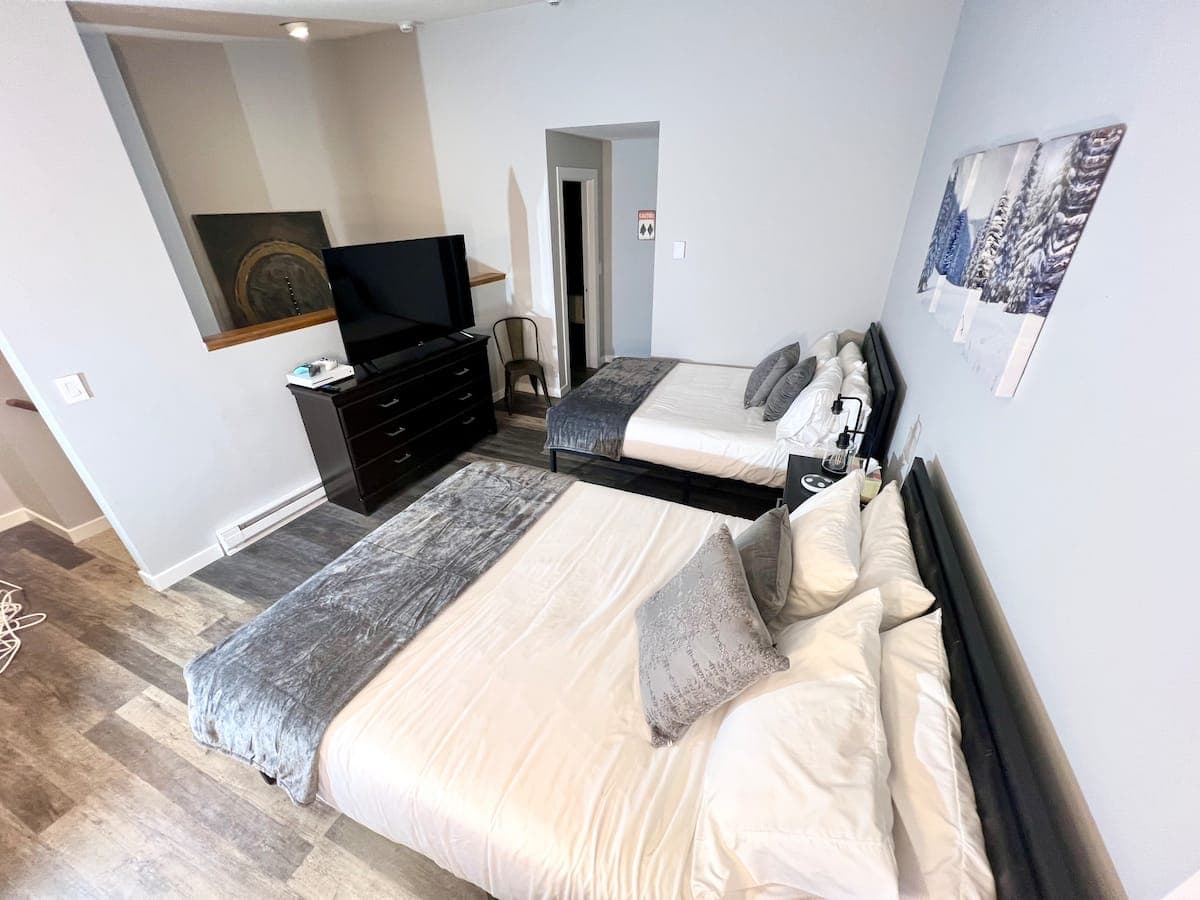 Bedroom 2 (upstairs) with two queen beds, Xbox, and full-size arcade machines