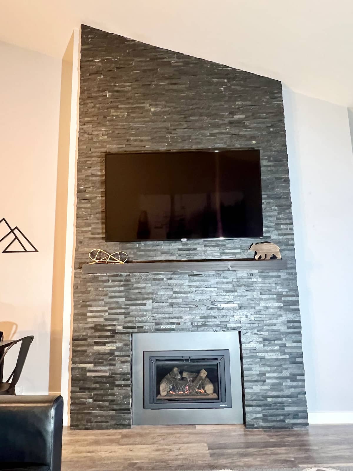 Living room with stacked-stone gas fireplace and 65-inch TV